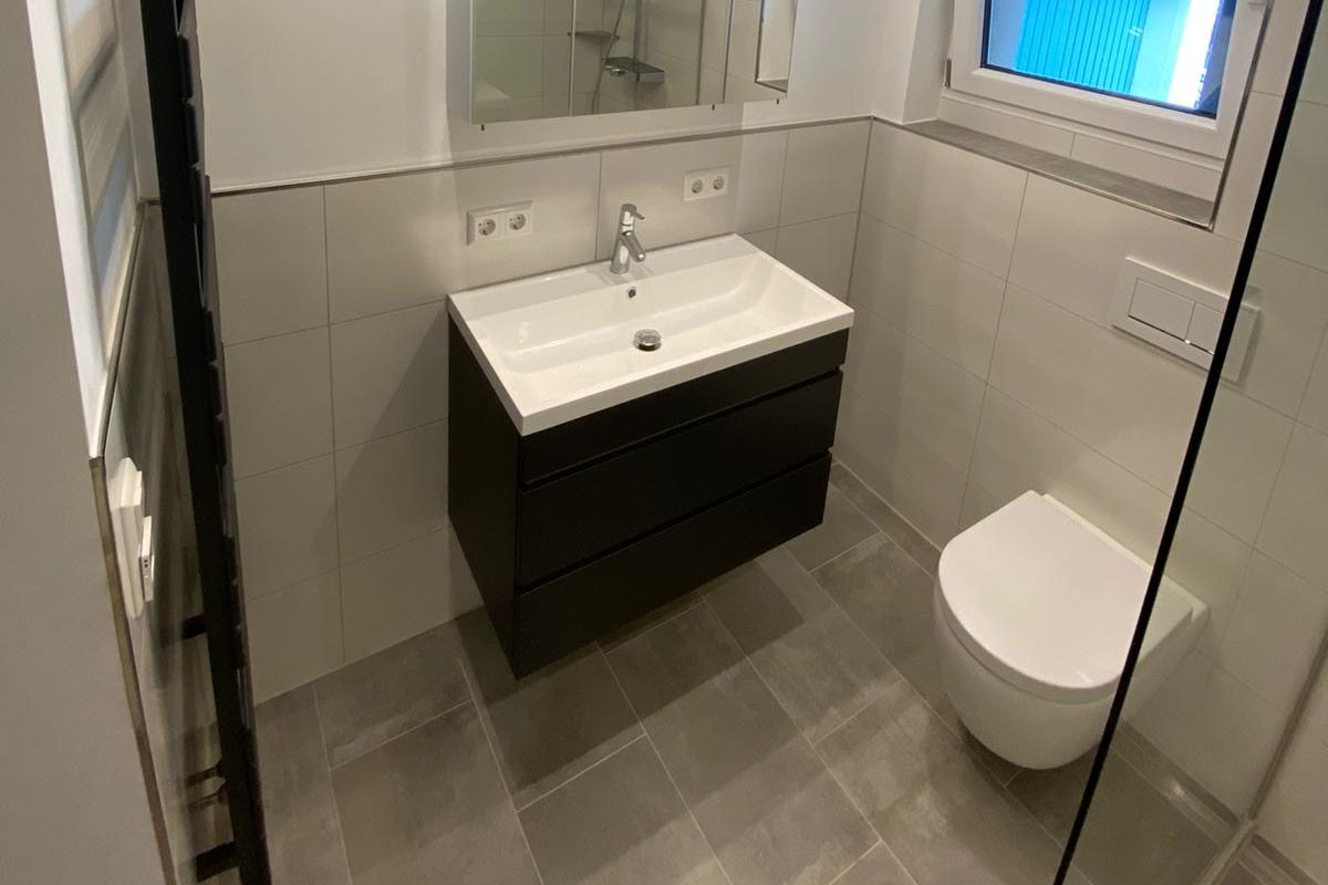 Modernes Badezimmer mit freistehender Badewanne, bodengleicher Dusche und stilvollen Armaturen.